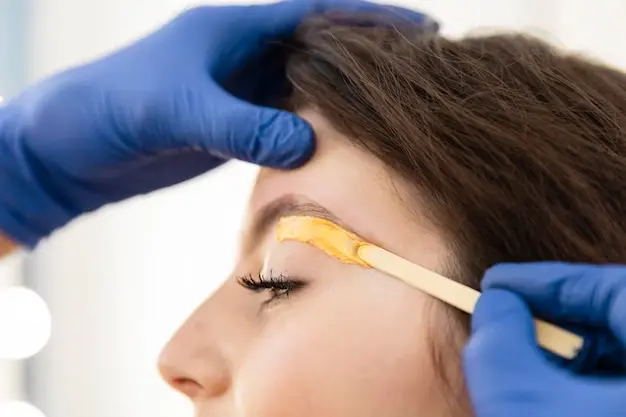 Proceso de depilación con cera en cejas